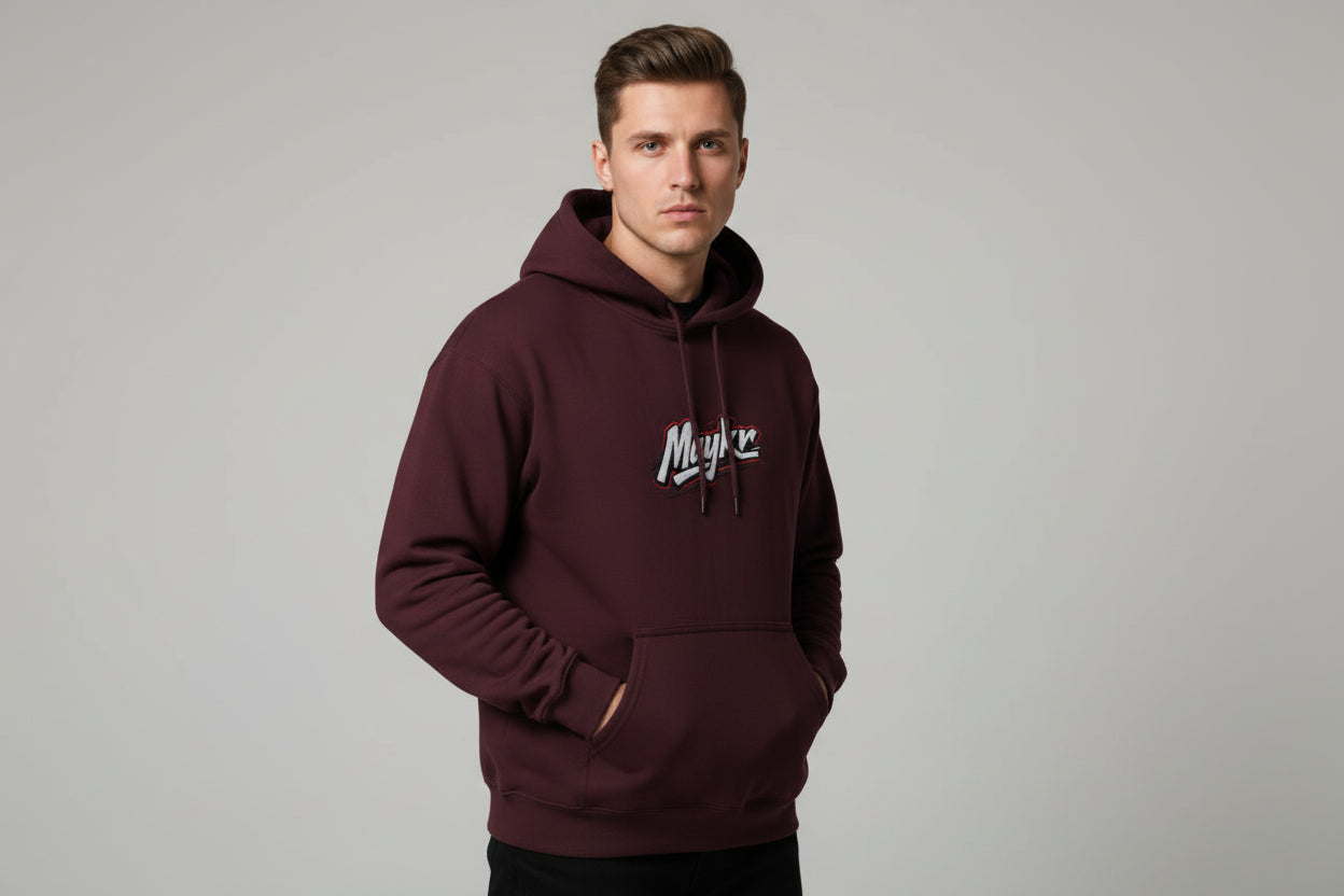Model in maroon MAYKR Classic Trend Hoodie with chest logo and kangaroo pocket.