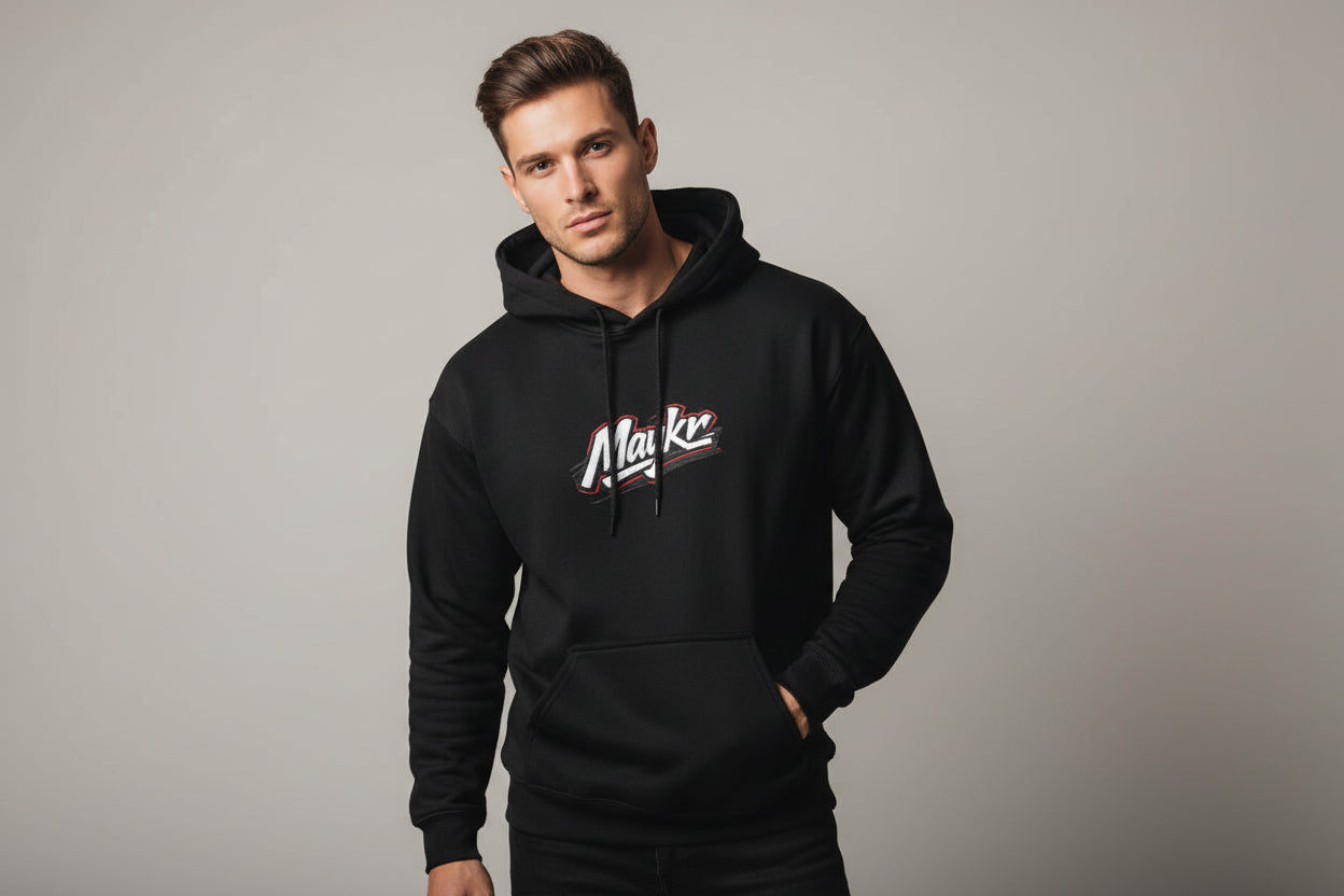 Man wearing black MAYKR Classic Trend Hoodie with chest logo; heavyweight 100% cotton, unisex regular fit.